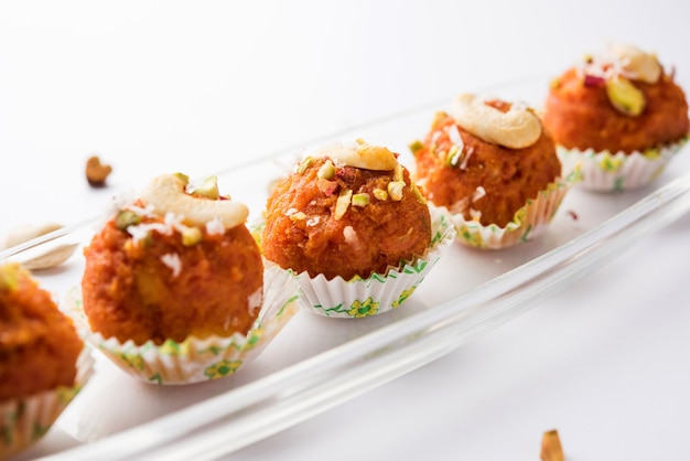 Carrot Halwa Laddu or sweet balls,  served in a plate with dry fruits toppings. selective focus