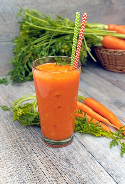 carrot juice in glass on wooden table