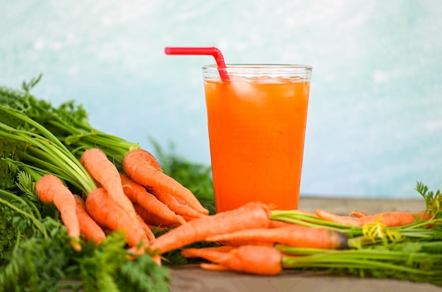 Carrot juice on wooden table background fresh and sweet carrots for cooking food fruits and vegetables for health concept fresh carrots juice on glass with ice on summer