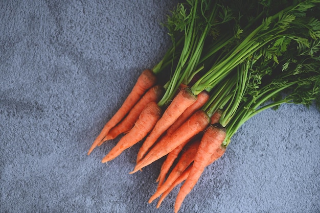 Carrot on table background Fresh and sweet carrots for cooking food fruits and vegetables for health concept baby carrots bunch and leaf