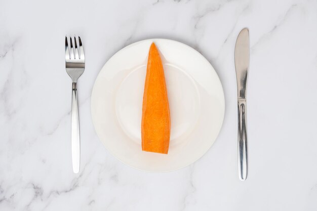 Carrot on a white plate top view