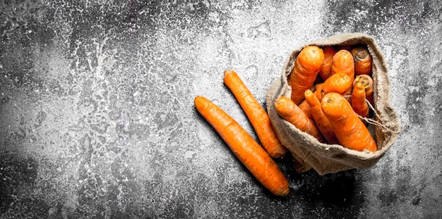 The carrots in the old bag. On rustic table.