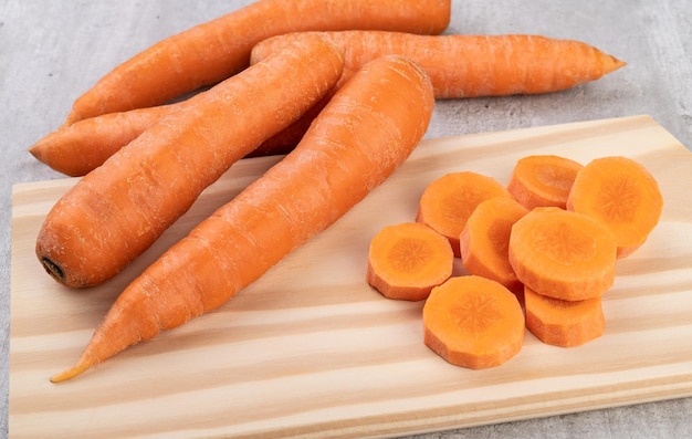 Carrots and slices on a board over wooden table