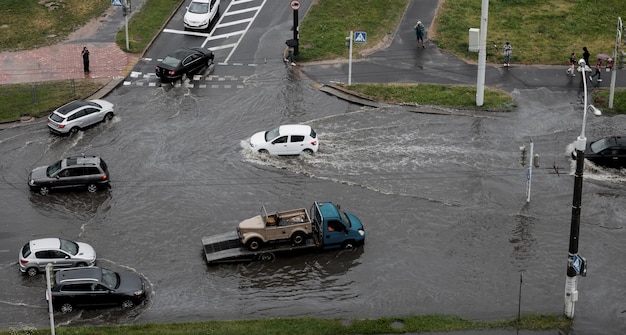 Cars are driving on a road flooded