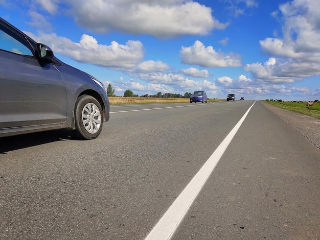 Cars drive along the road on a sunny summer day