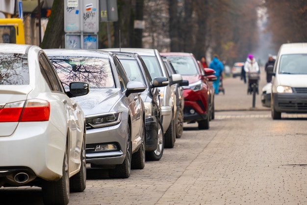 Cars parked in a row on a city street side.