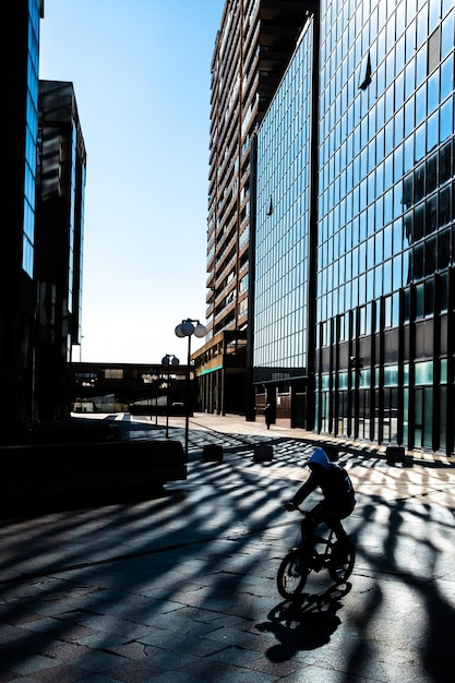 Photo cars on street by modern buildings in city against sky