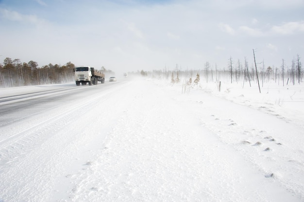 Cars on the winter road in snowstorm time. Risk of snow and ice. Blizzard.