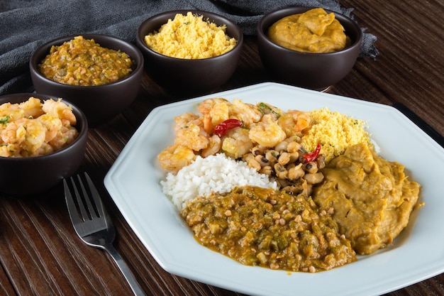 Caruru Traditional AfroBrazilian dish made with okra and dried shrimp accompanied by vatapa beans rice shrimp and farofa