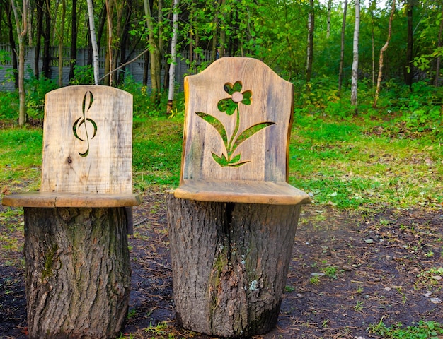 Carved chairs made of logs in the forest.