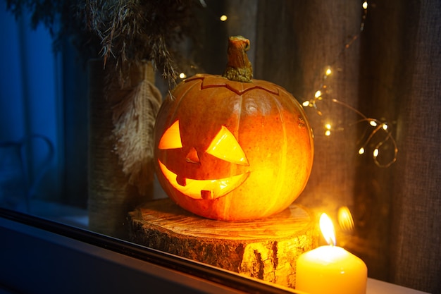 The carved pumpkin looks out the window. Jack Lantern, Halloween concept.