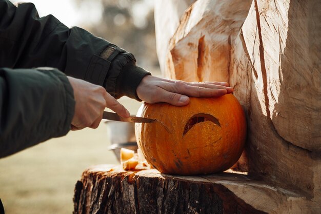 Carving pumpkin into jack lantern for halloween holiday decoration outdoor