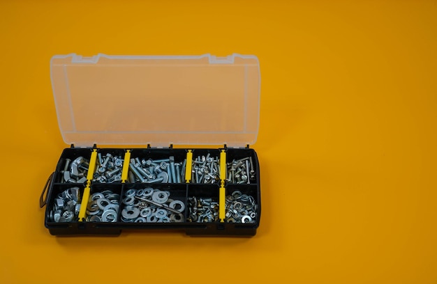 Case organizer with screws nuts and washers on a yellow background Located on the right