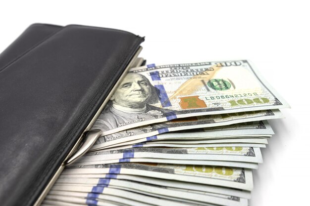 Cash from one hundred dollar bills in a wallet on a white background A lot of US dollars in a black wallet