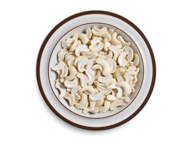 Cashew halves or Indian nuts in plate on white