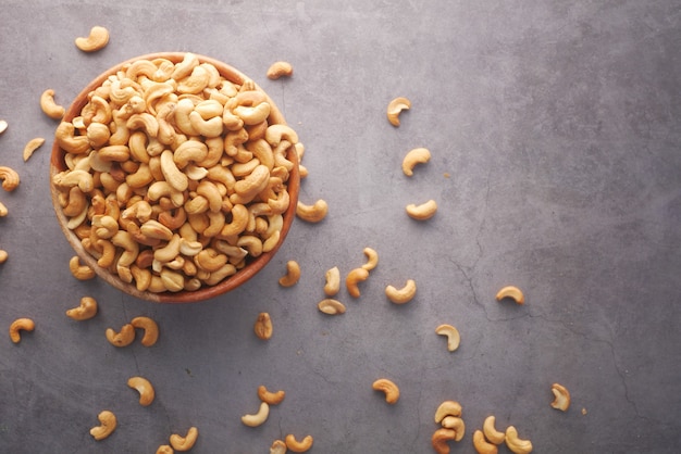 Cashew nuts in a bowl on black background  top view