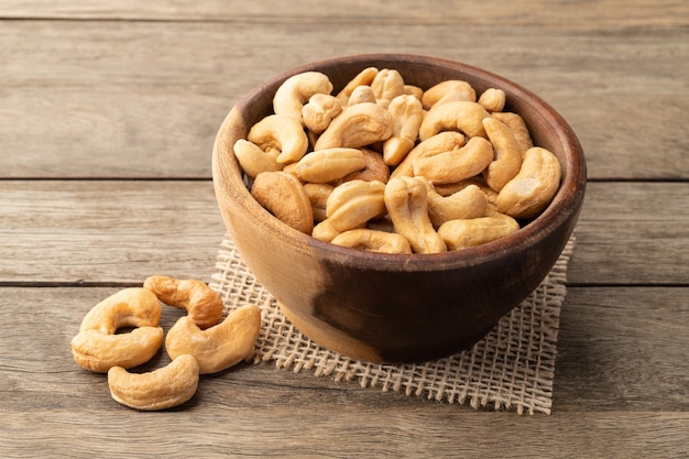 Cashew nuts in a bowl over wooden table.