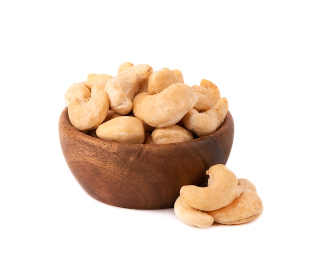 Cashew nuts in wooden bowl, isolated on white background. Roasted cashew nuts.