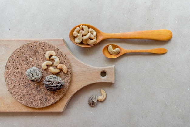 Cashew nuts and wooden spoons on craft paper background