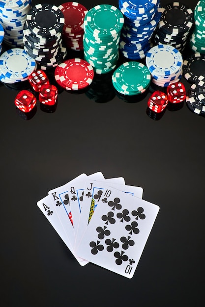 Casino chips playing cards and dices on dark reflective background