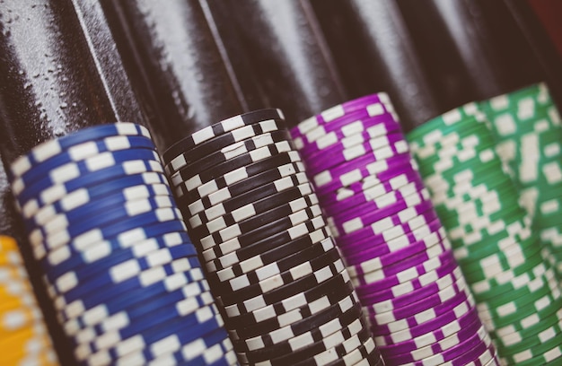 Casino colorful poker chips lie on the game table in the stack vintage photo processing