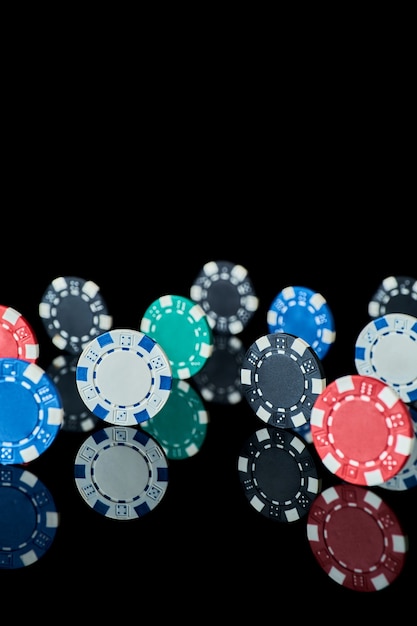 Casino gambling chips isolated on black reflective background