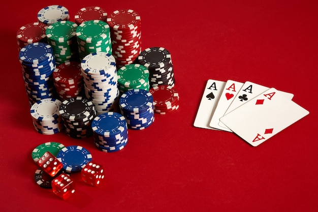 Casino gambling poker equipment and entertainment concept - close up of playing cards and chips at red background. Four of a Kind. Casino background. Copy space. Still life