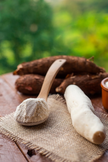 Cassava flour with cassava in the background on a farm