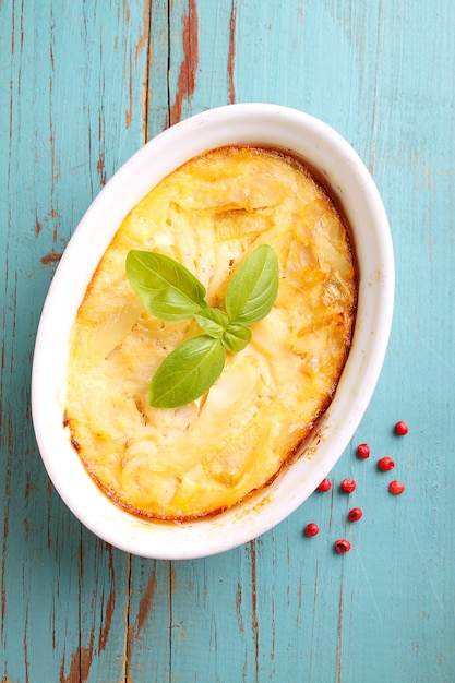 Casserole with fish in a white dish on a blue background