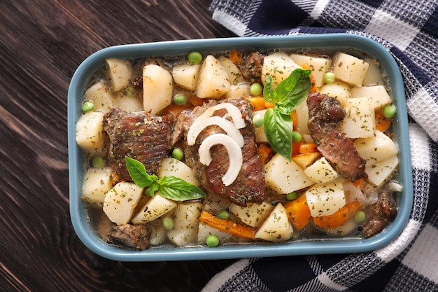 Casserole with tasty meat and potatoes on wooden background