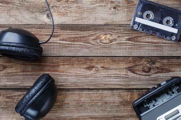 Cassette tapes, cassette player and headphones over wooden table. top view. Retro concept with empty space for text, logo, etc.