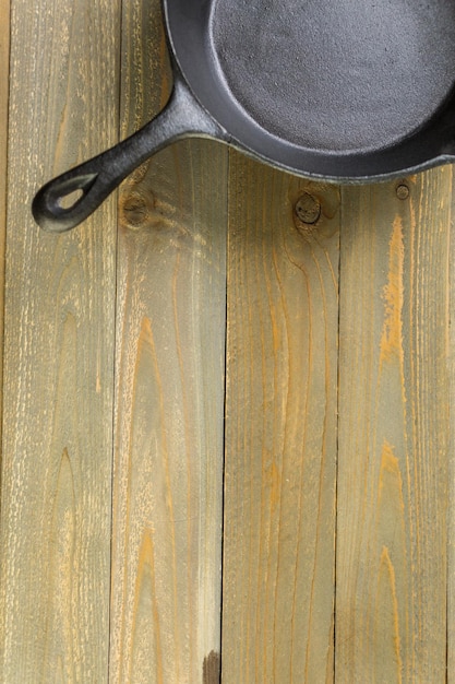 Cast iron skillet on rustic wood table.