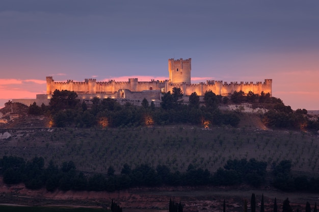 Castillo de Peafiel in the province of Valladolid illuminated at sunset Seen from afar Golden light