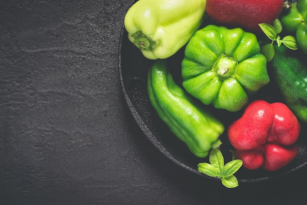 Castiron dish with different red and green bell peppers With drops of water