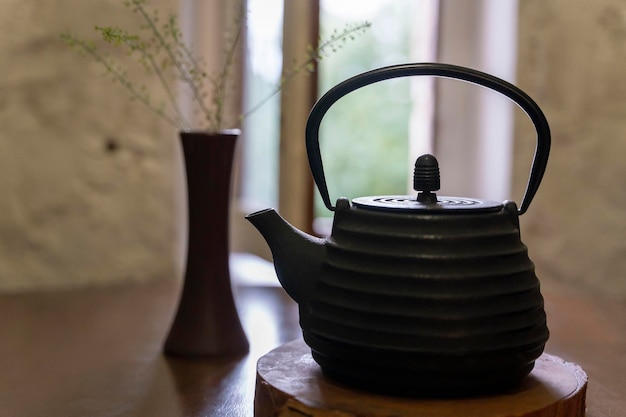 Castiron kettle on a wooden stand on the restaurant table