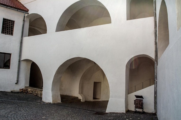 Castle courtyard with white arches and stone pavement