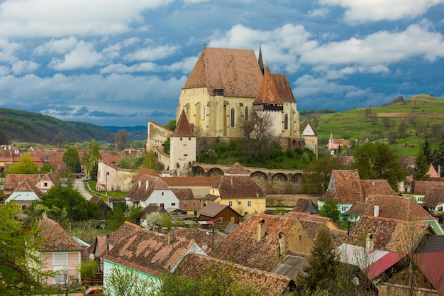 Photo a castle in the mountains with a cloudy sky