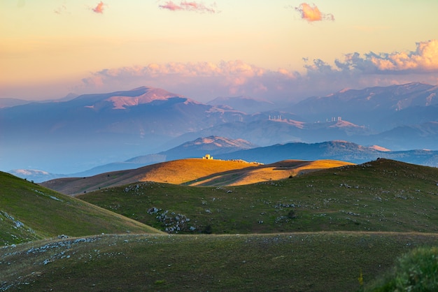 Castle ruins and small chapel at Rocca Calascio italian travel destination, landmark in the Gran Sasso National Park, Abruzzo, Italy. Sunset view