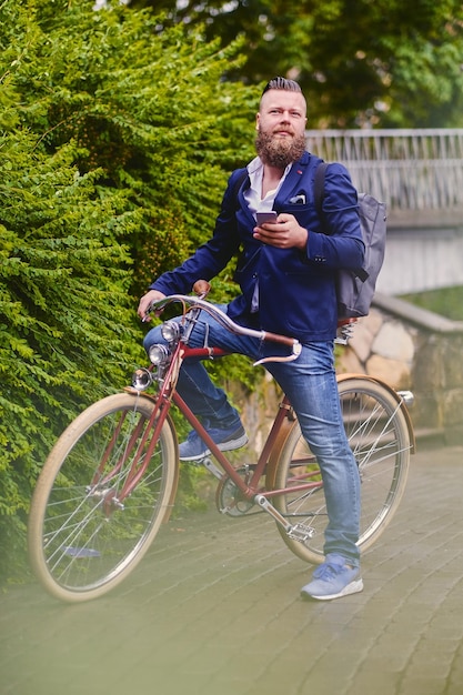 Casual bearded male in a park talks by smart phone.