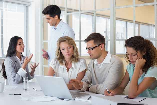 Casual business team having a meeting using laptop