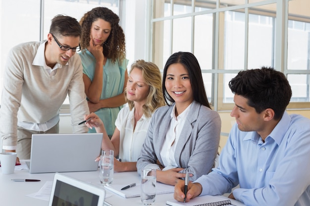 Casual business team having a meeting using laptop