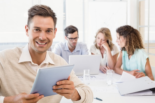 Casual businessman smiling at camera during meeting