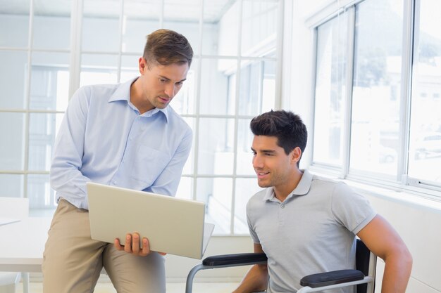 Casual businessman in wheelchair talking with colleague