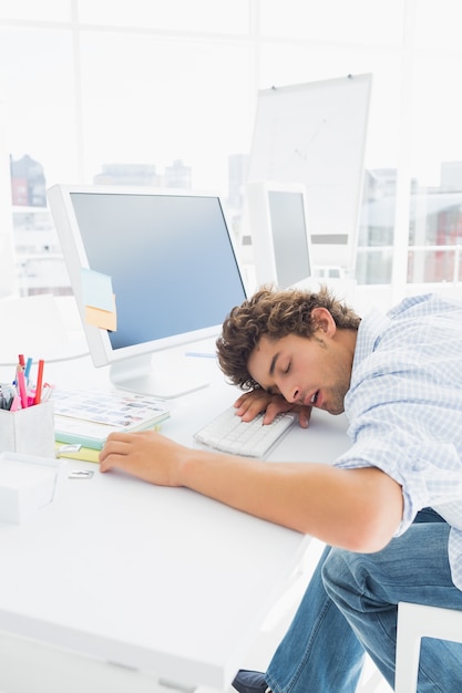 Photo casual businessman with head over keyboard at desk