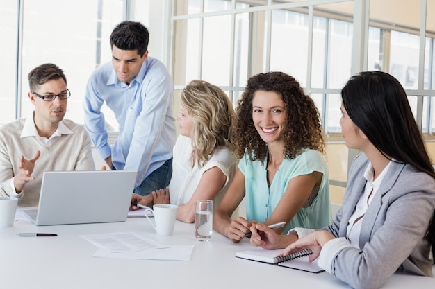 Casual businesswoman smiling at camera during meeting