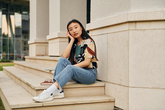 In casual clothes Young asian woman is outdoors at daytime