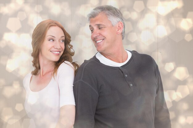 Photo casual couple smiling at each other against light glowing dots design pattern