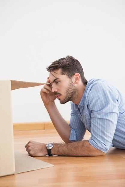 Casual man looking inside cardboard box