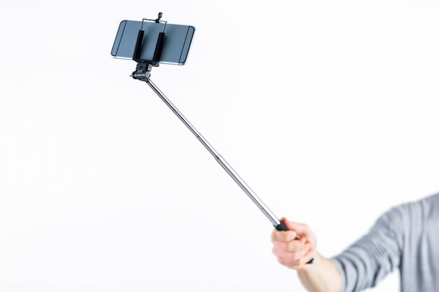 Casual man using a selfie stick shot in studio