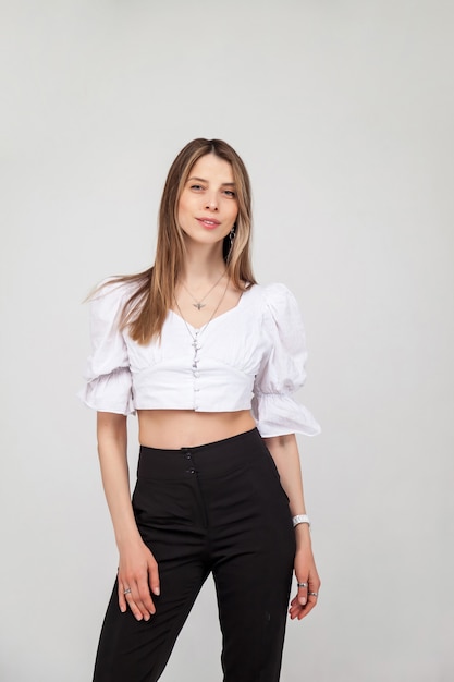 Casual portrait of pretty blonde young woman with hairstyle smiling cheerfully, showing emotion while feeling happy and carefree. Young cute cheerful girl looking at camera over white background